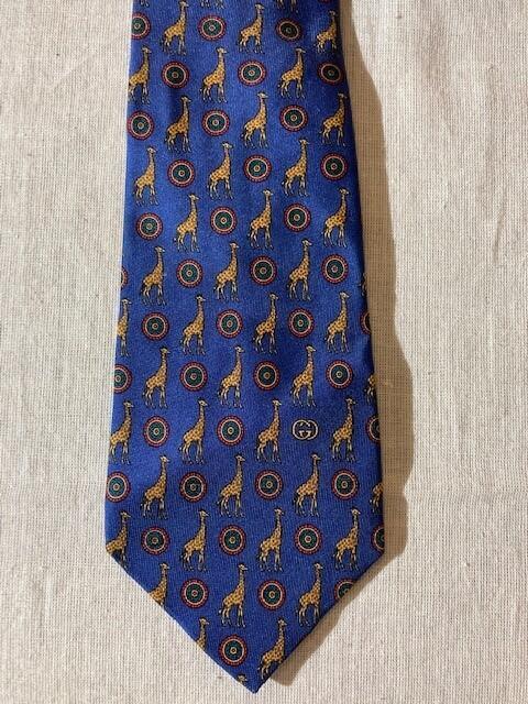 Das, zijde, blauw fond, bedrukt met gestileerde bloemvorm groen rood en kleine giraffes