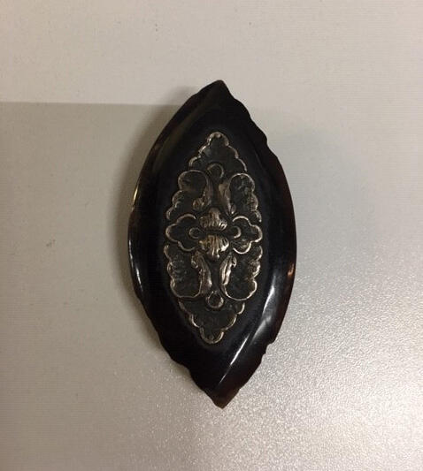 Clip. Schildpad of imitatie schildpad. Ovale vorm. Decoratie gestileerd bloempatroon van zilver…