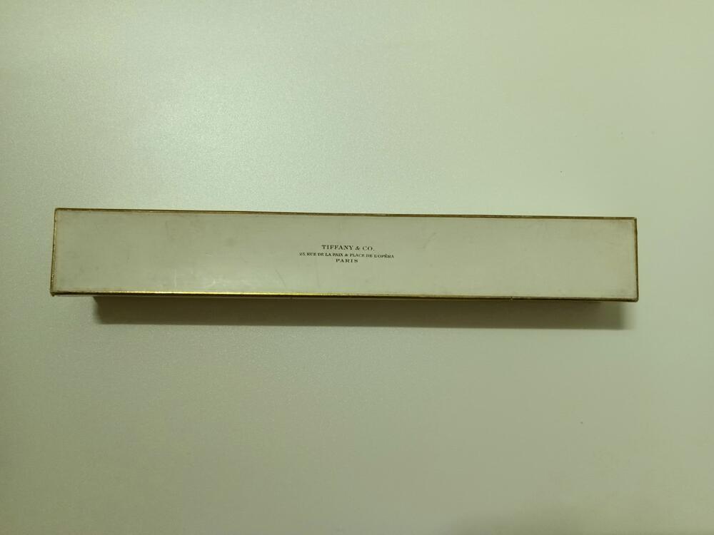 Waaierdoos van wit karton met goudkleurige rand, bovenop deksel logo Tiffany & Co