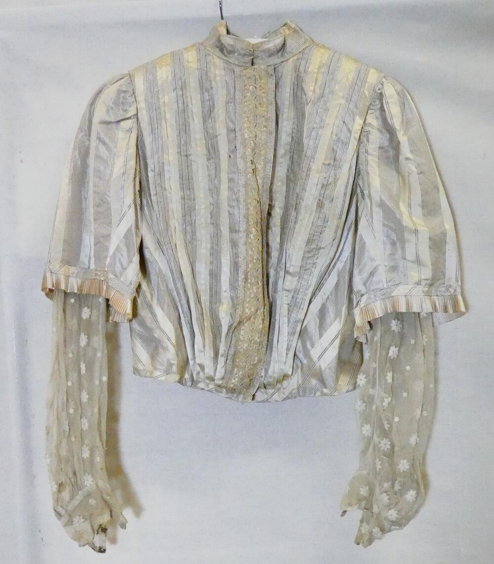 Blouse van crèmekleurige zijde met zwarte streepjes en effen satijnstrepen. Tule onder mouwen met…