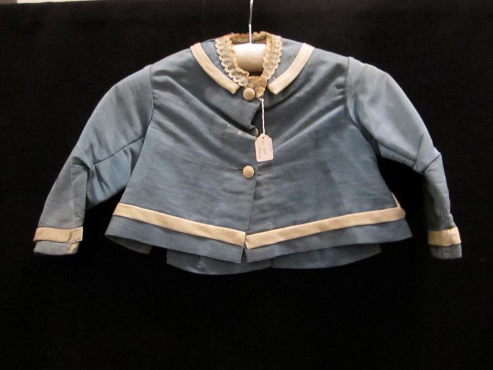 Jasje of Jak (kind) van helderblauwe stof met witte garneringen