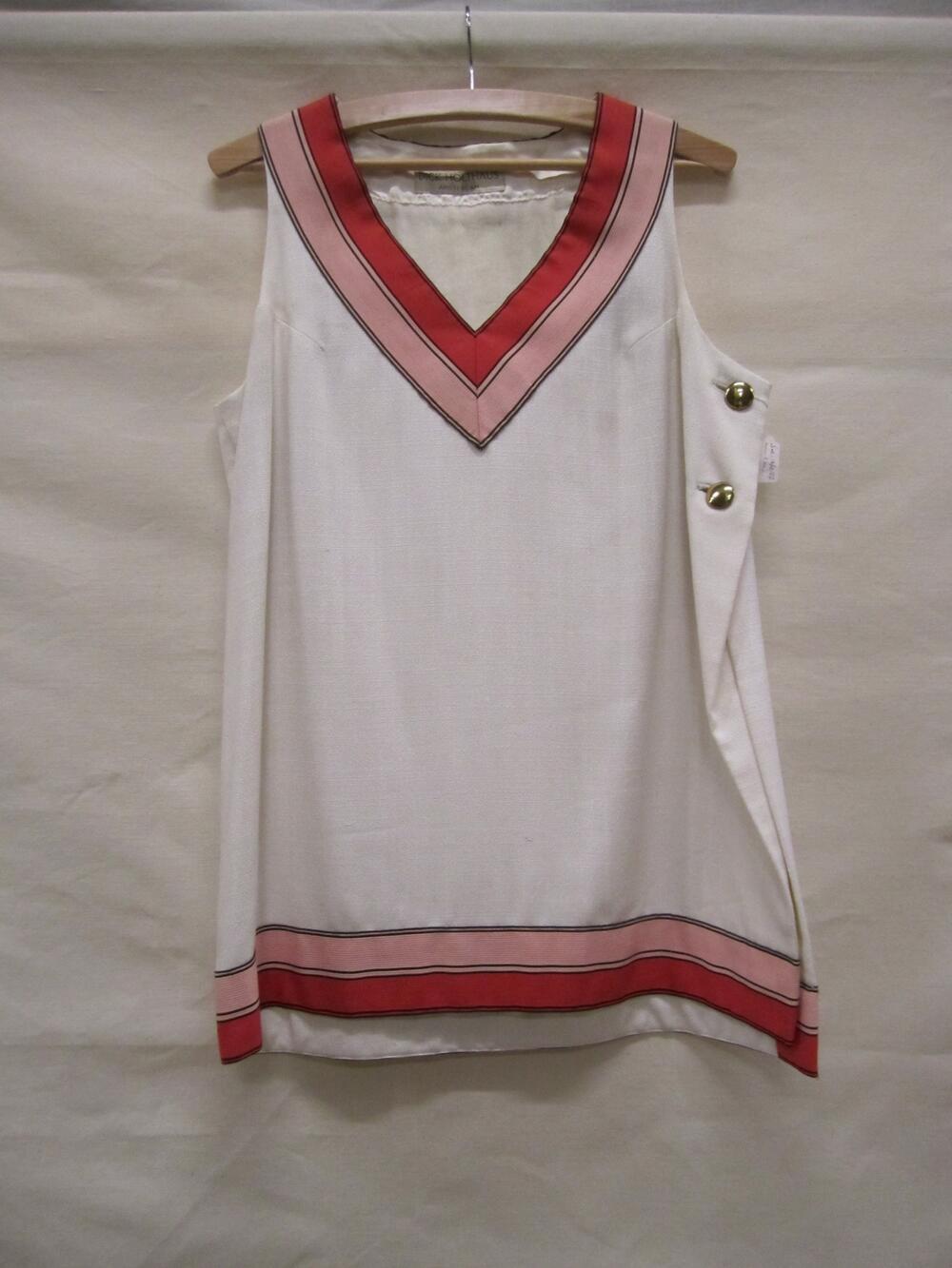 Tuniek in linnenlook van witte fibranne (?), met diepe V-hals en links een ruime split, afgezet met…