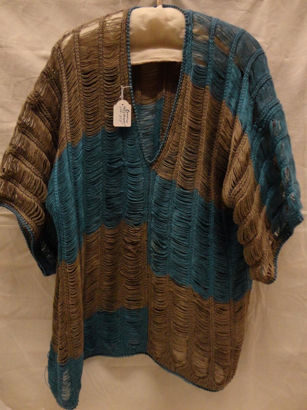 Trui van opengewerkt linnen tricot met turquoise en grijze vlakken. V-hals en ingezette driekwart…
