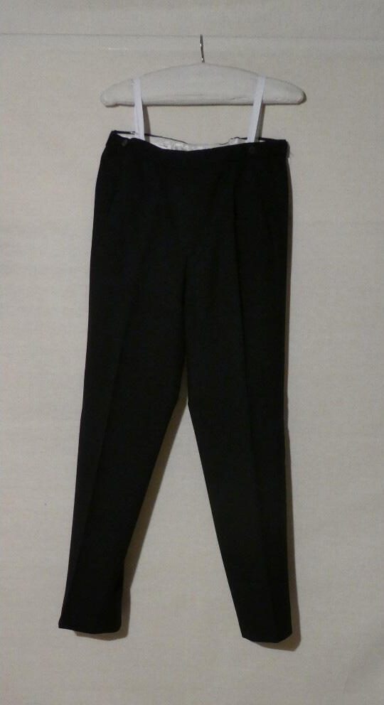 Broek (man) van donkerblauwe wol, behorende tot pak. Iets laag model met rechte wijde pijp met vouw