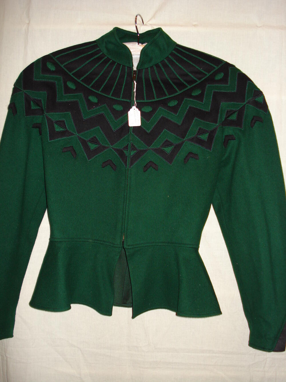 Jas, kort getailleerd model van groene wol met zwarte geometrische motieven bij de schouders