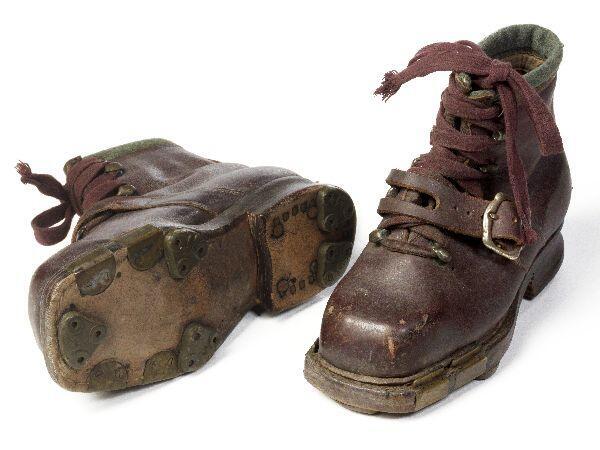 1 paar skischoenen (kind) van bruin leer met omslag van groene wol. Sluiting middels 10 haken van…