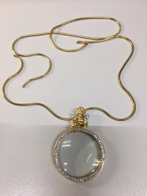 Ketting. Metaal in goudkleur. Lang snoer, gebroken en sluiting ontbreekt. Hanger van rooskwarts…