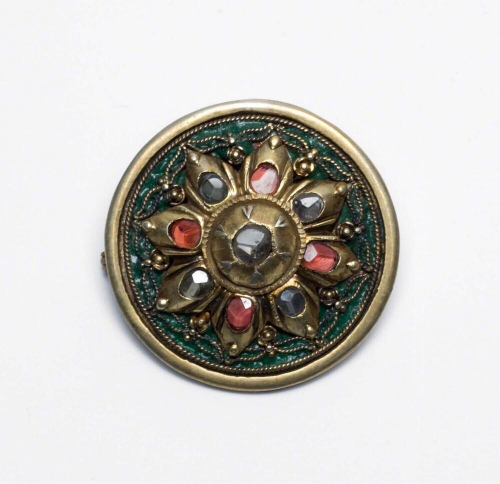 Messingen broche met sierstenen, vervaardigd uit een oorsieraad