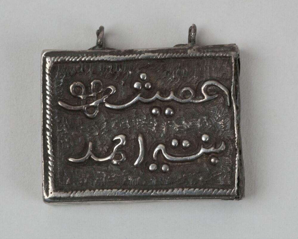 Zilveren amulet om de hals gedragen