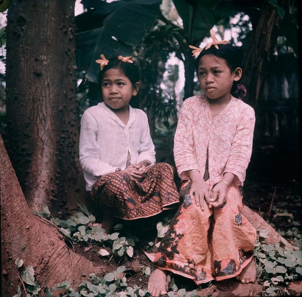 Two girls, wearing cempaka flowers in their hair