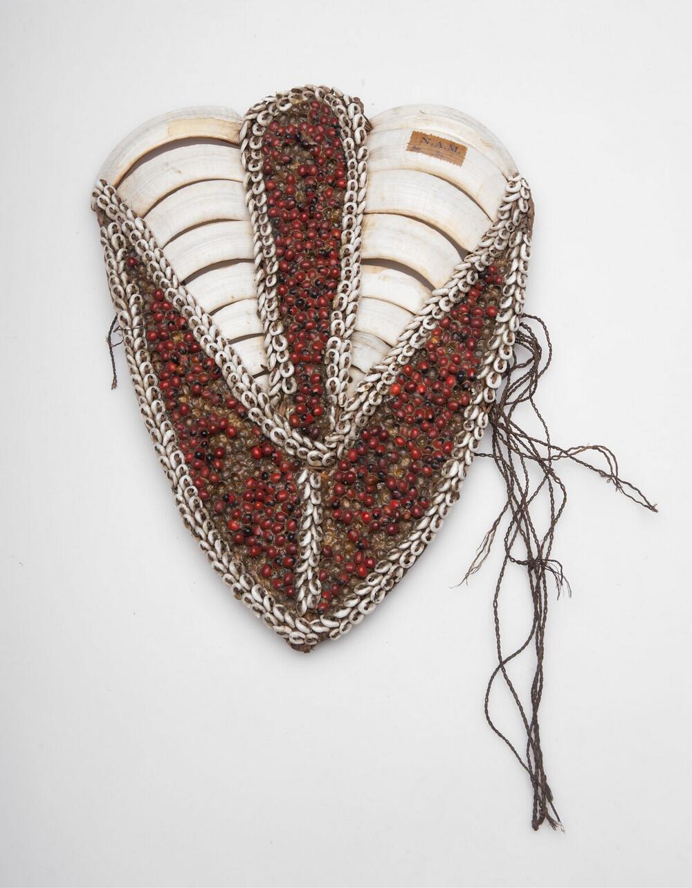 Breast adornment made of seed, pig teeth en nassa shells