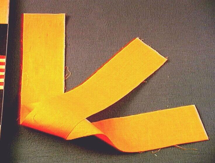 Een oranje mousseline doek, onderdeel van een vijfdelige kledingset van een noviet.