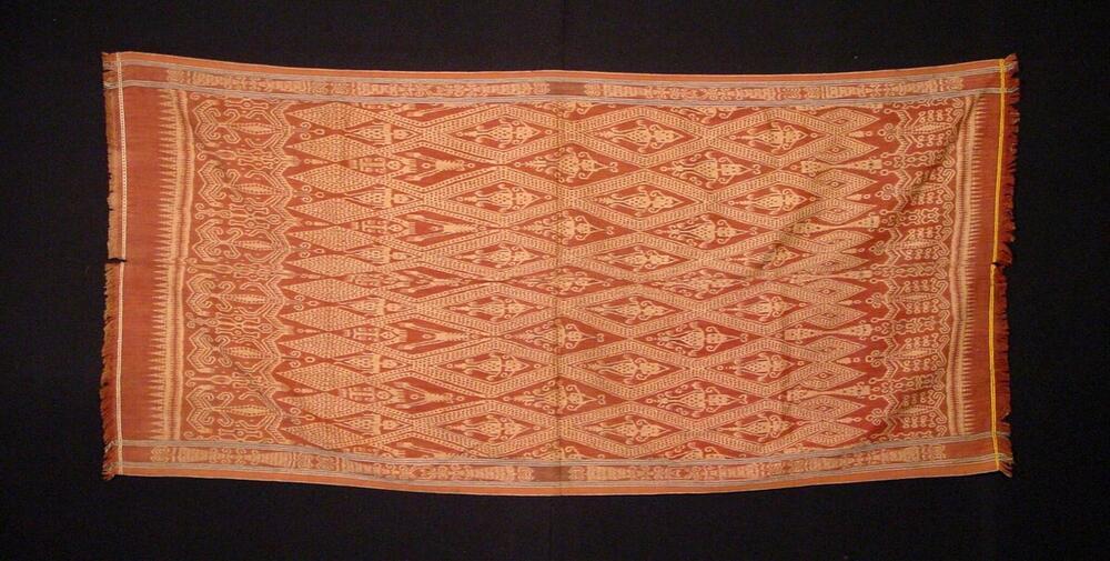 Katoenen doek met ruitpatroon waarin gestyleerde figuren in schering ikat