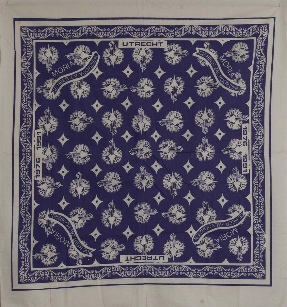 Hoofddoek met tekst: 'Moria. de heer zal voorzien' en de data 1976-1991
