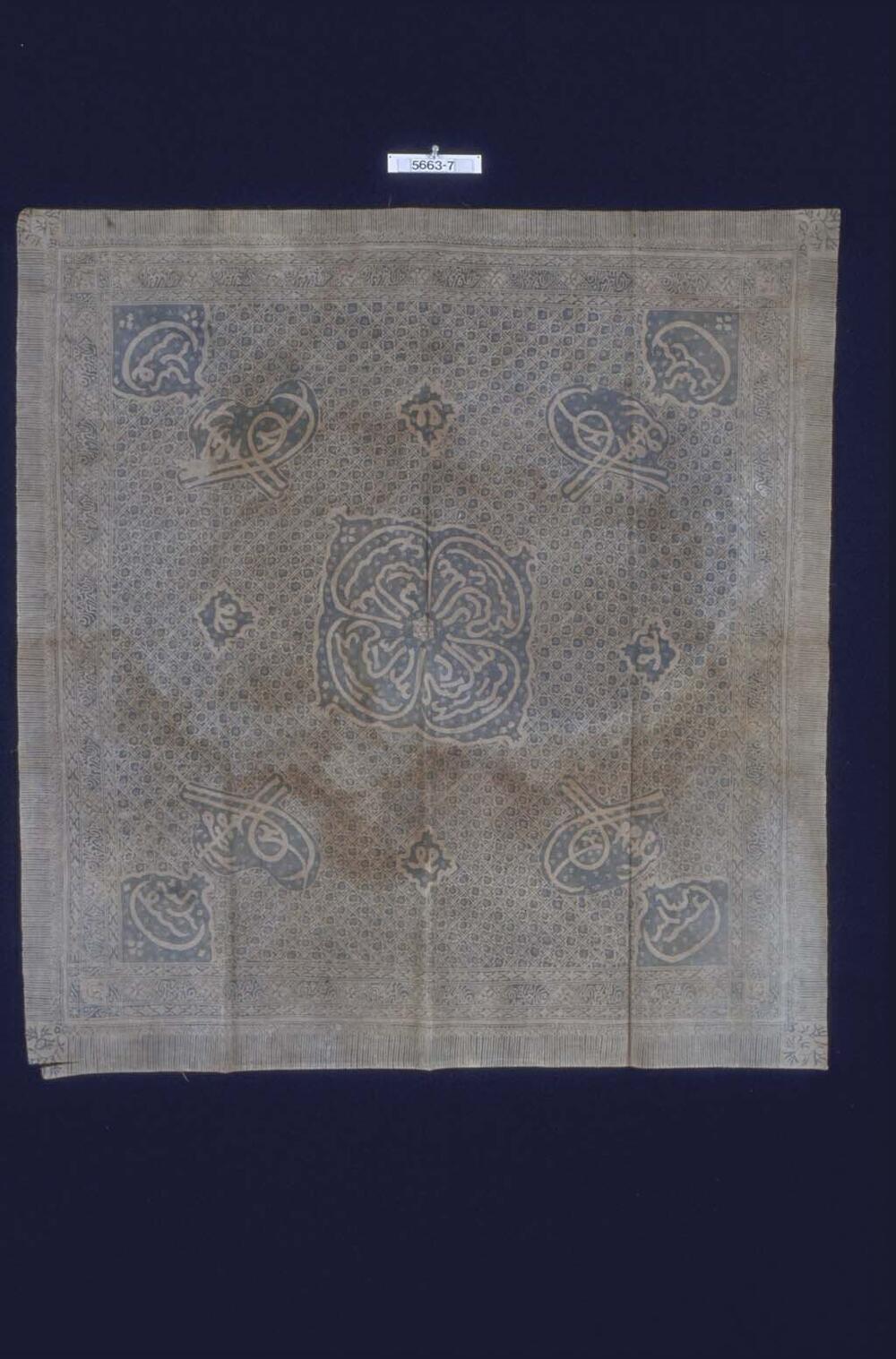 Blauw-witte hoofddoek voor man met kalligrafie, gebruikt om een Koran in te wikkelen