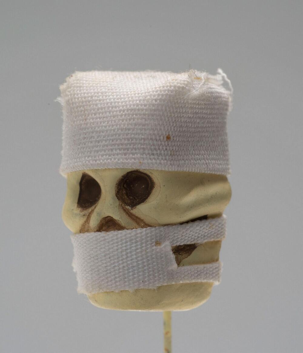 Kledingspeld in de vorm van het doodshoofd van een chirurg, vervaardigd voor Allerzielen