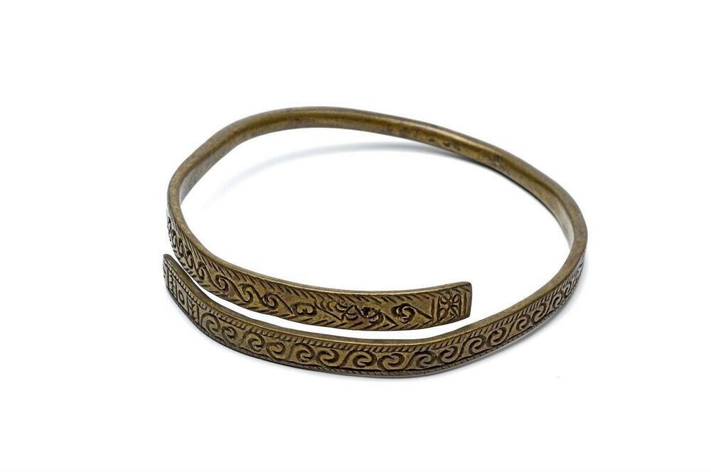 Messingen armband, versierd met krulmotieven
