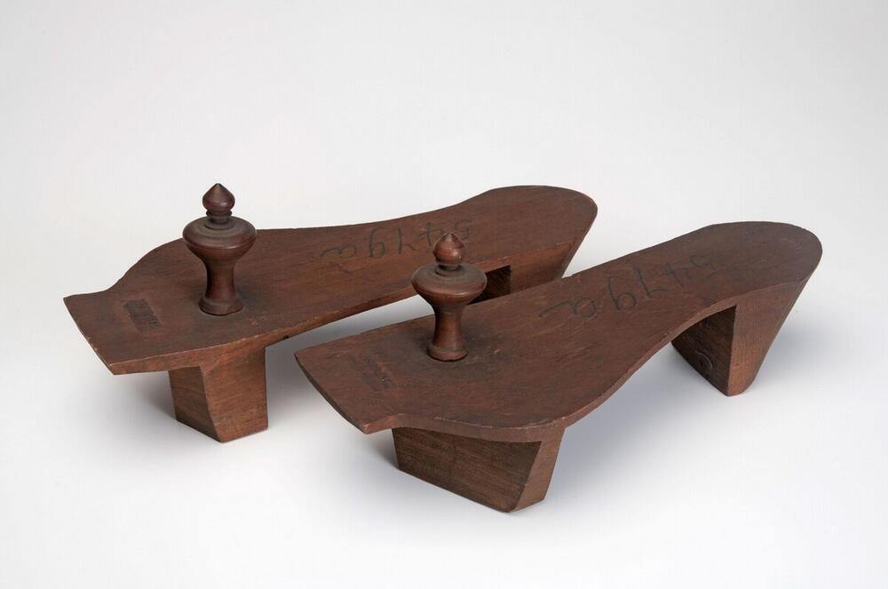 Een paar houten slippers met houten knoppen