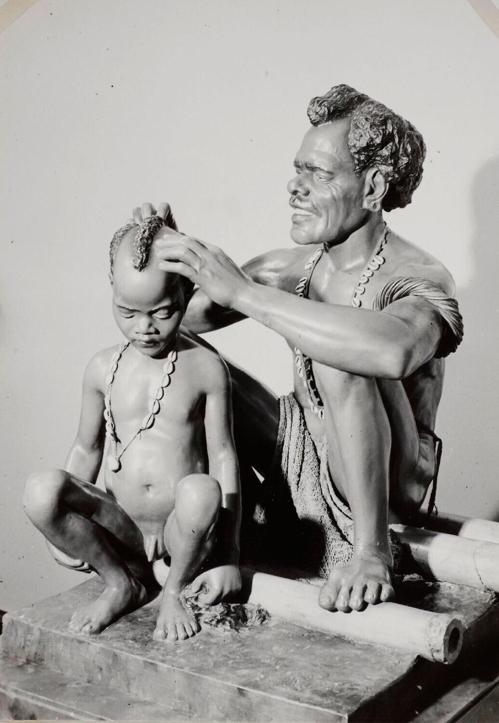 Beeldengroep van een Papua man en kind in het Tropenmuseum