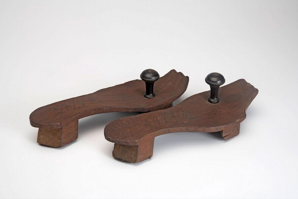 Een paar houten slippers met houten knoppen