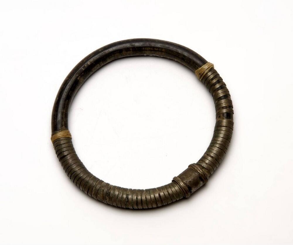 Armband van zwart buffelhoorn, omwonden met metaalrepen
