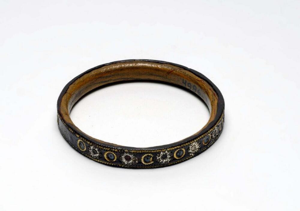 Houten armband met plastic laag, versierd met ingedrukte decoraties