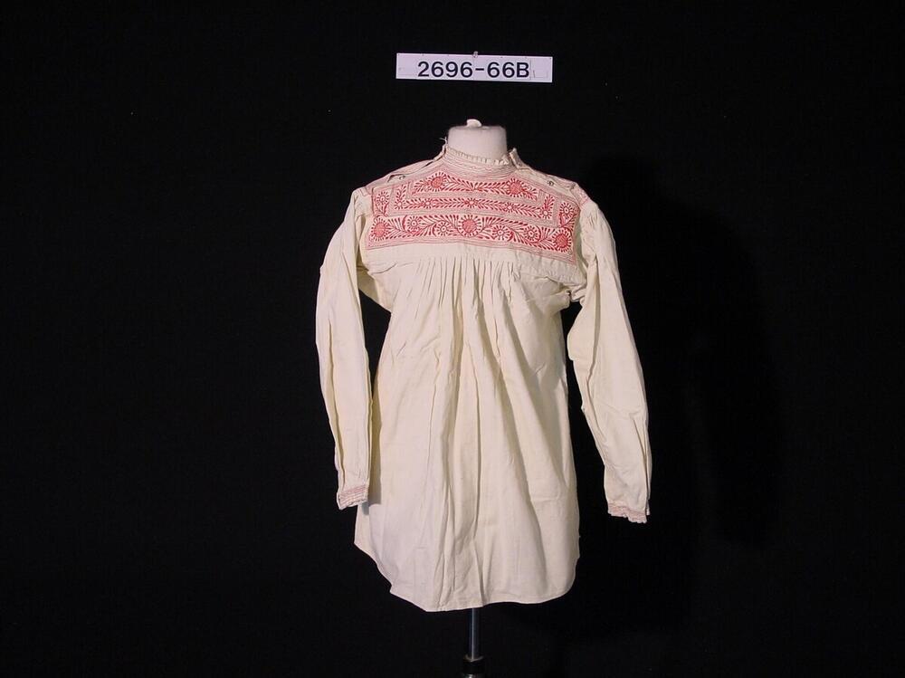 Wit katoenen blouse met rode borduursels als onderdeel van trouwkleding voor een vrouw