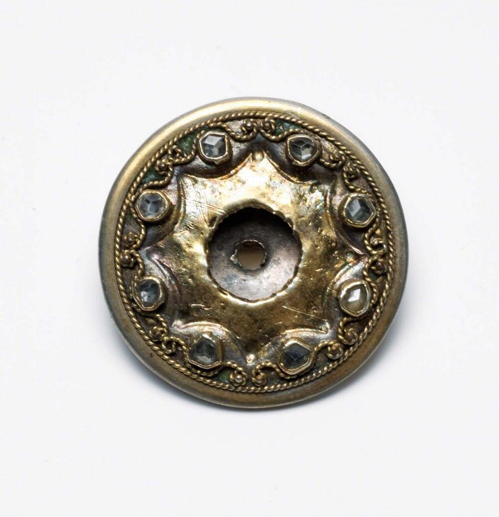 Broche van zilver en koper met sierstenen, vervaardigd uit een oorsieraad