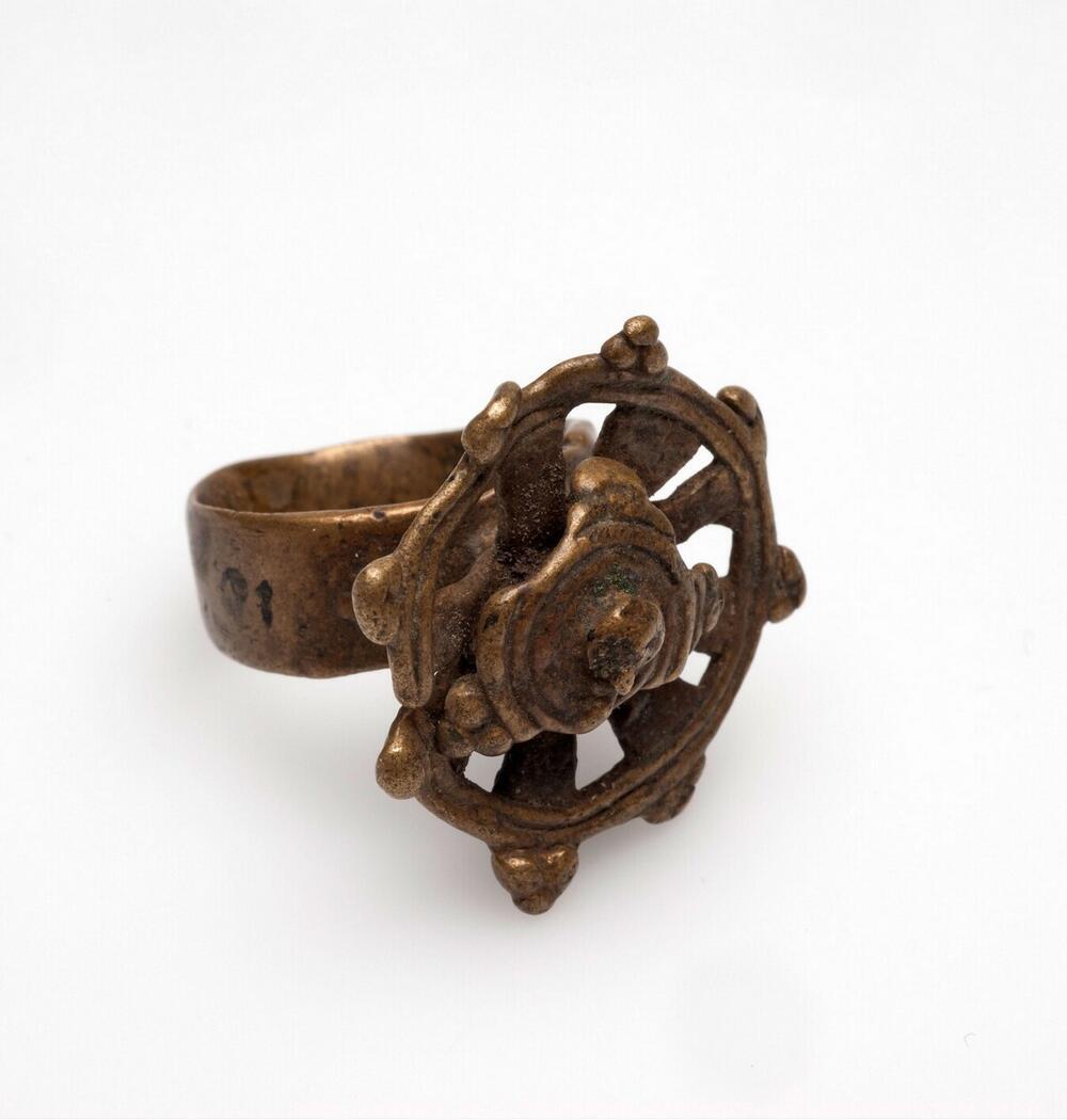 Messingen vingerring met een ornament in de vorm van een wiel met een bloem