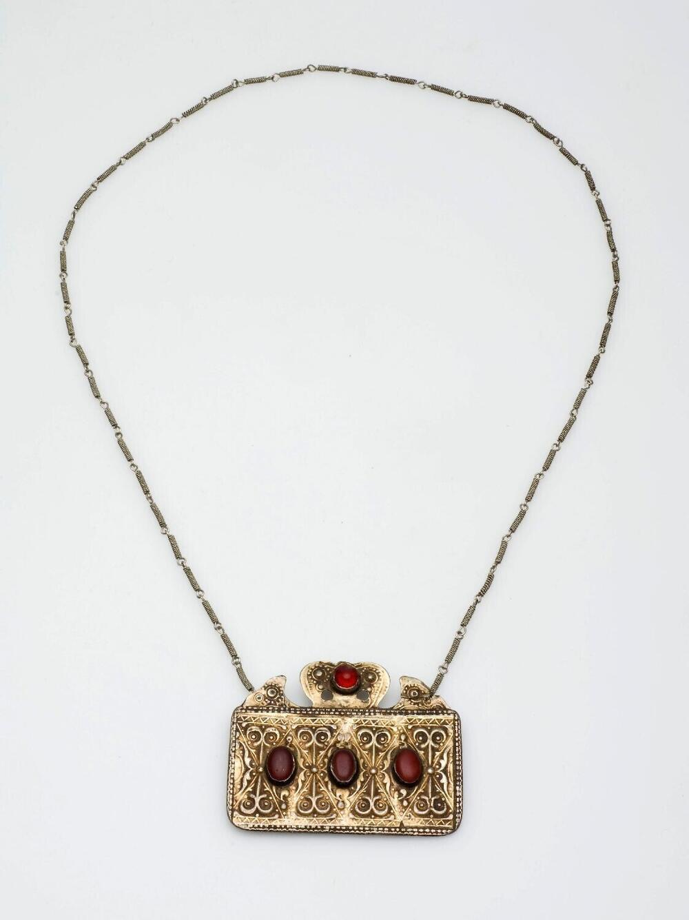 Zilveren ketting met hanger voorzien van rode stenen
