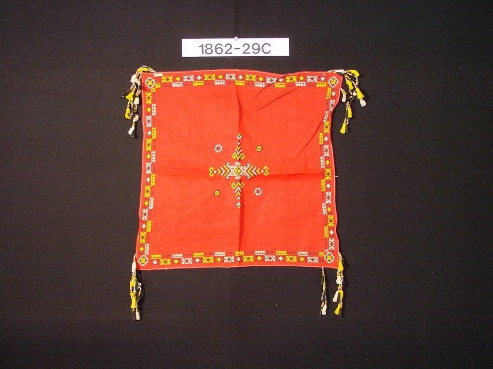 Vierkante hoofddoek, rood katoen met borduurwerk, als onderdeel van mannenfeestkostuum.
