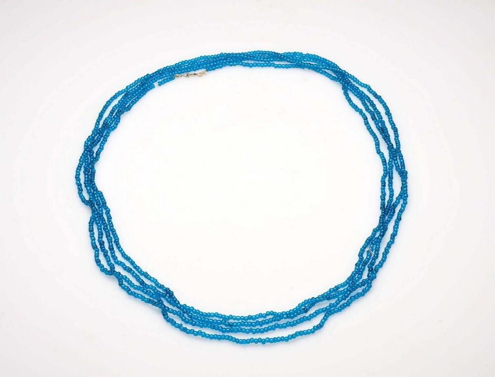 Zeer lange ketting van blauwe kralen, die verschillende malen rond de hals wordt gedraaid