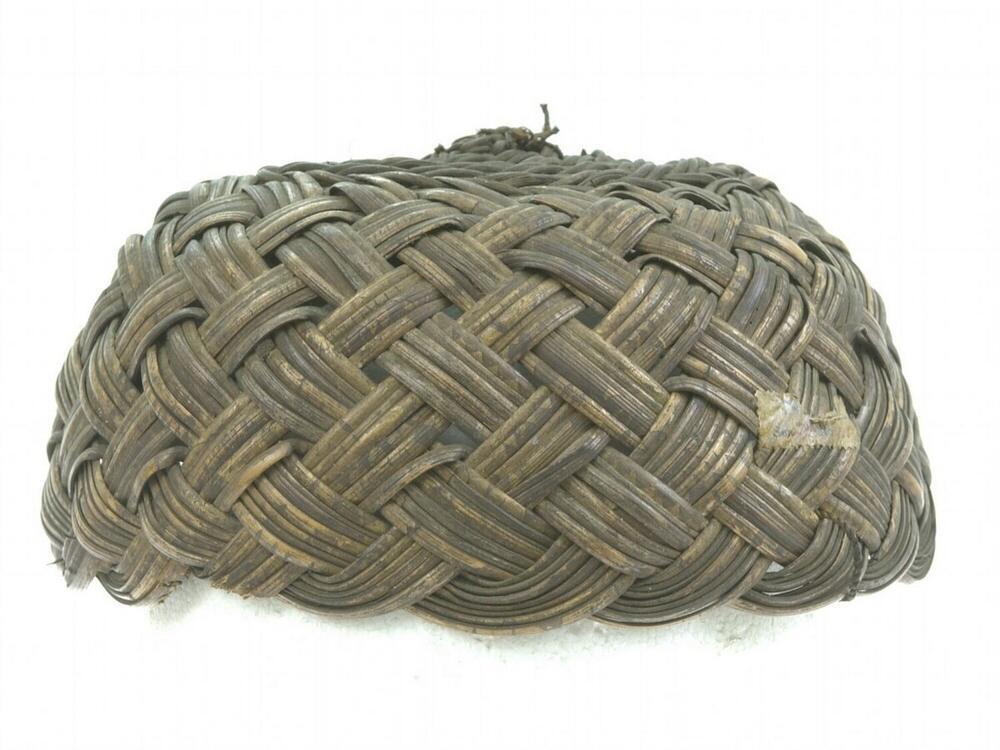 Strijdmuts van gevlochten rotan versierd met drie staartveren van de aegusfazant