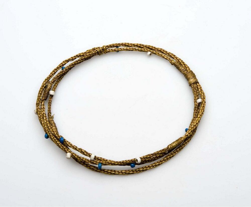 Bovenarmband van ineengevlochten gras met kraalversiering