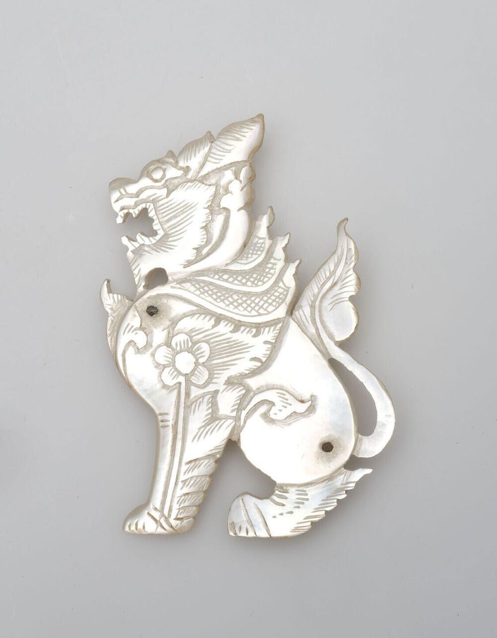 Broche van parelmoer, in de vorm van een zittende leeuw