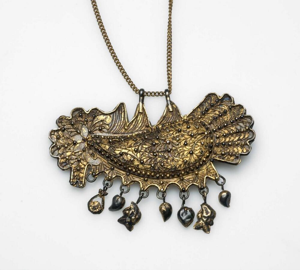 Messingen hanger in de vorm van een haan met bedels, aan een ketting