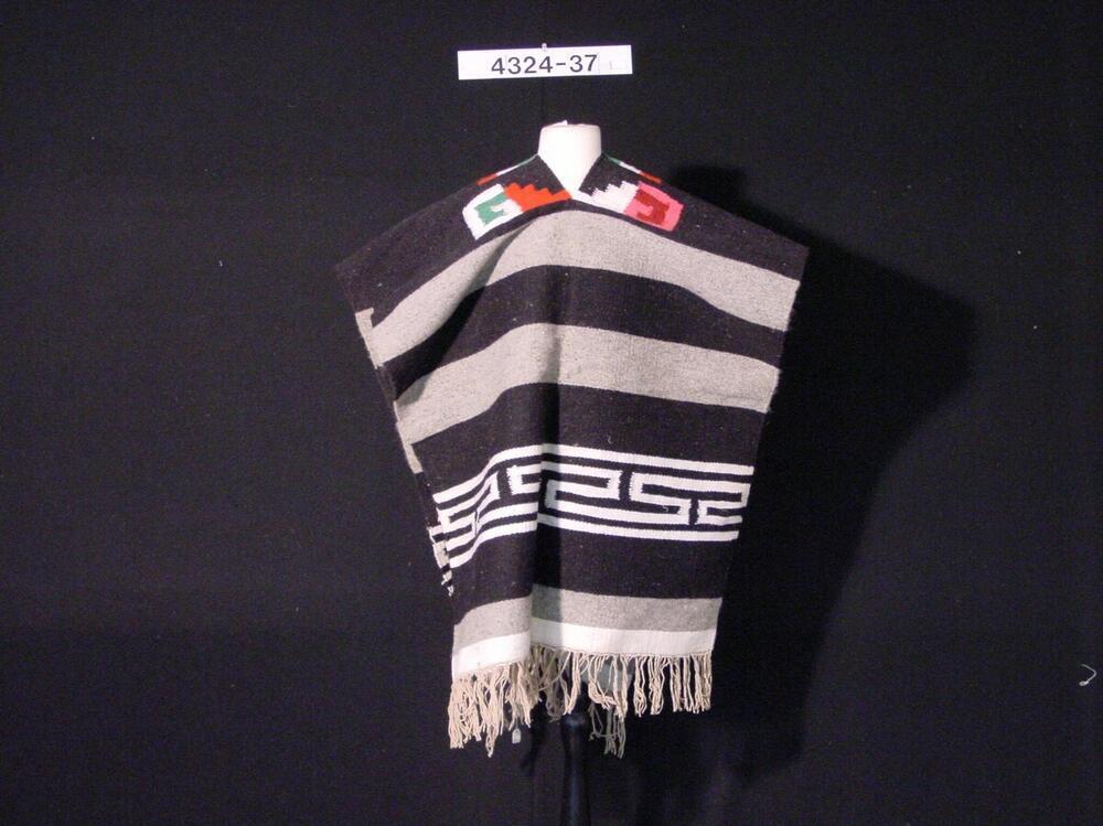 Katoenen poncho met horizontale banen in verschillende kleuren, en één met groot meandermotief