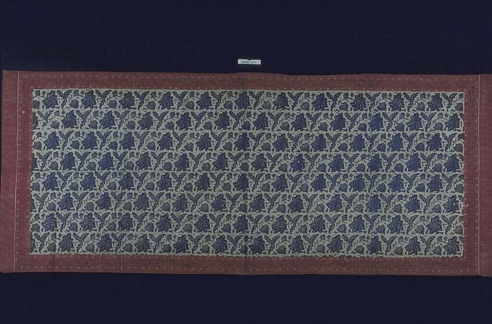 Katoenen schouderdoek door K.M.R.H. met een symmetrisch geheel aan zich repeterende grote blauwe…