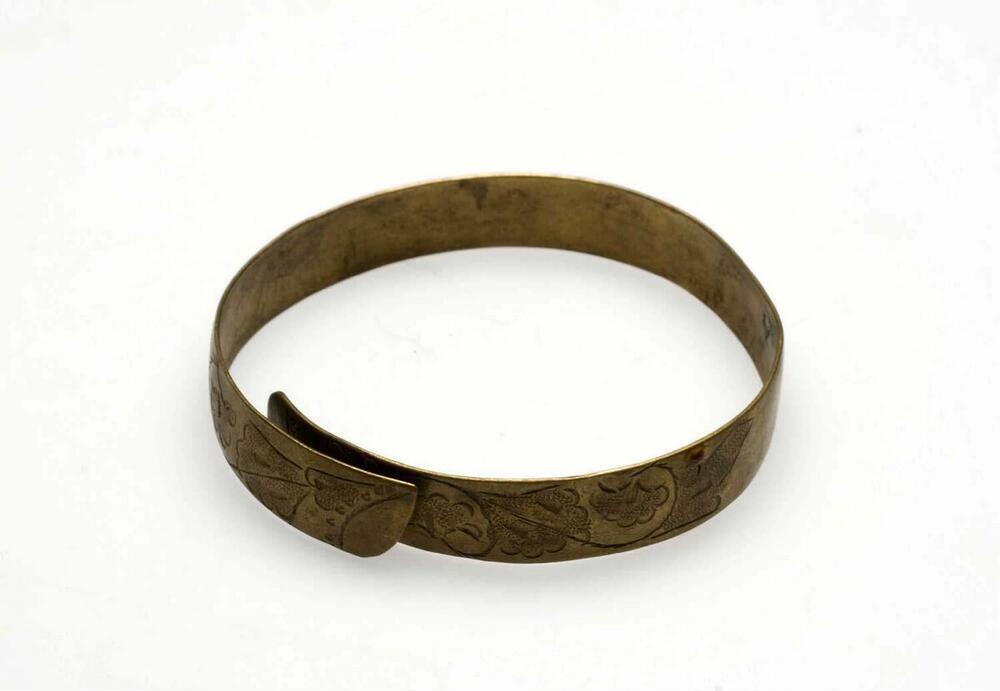 Messingen armband versierd met ciseleerwerk in de vorm van bloem- en bladmotieven, onderdeel van…