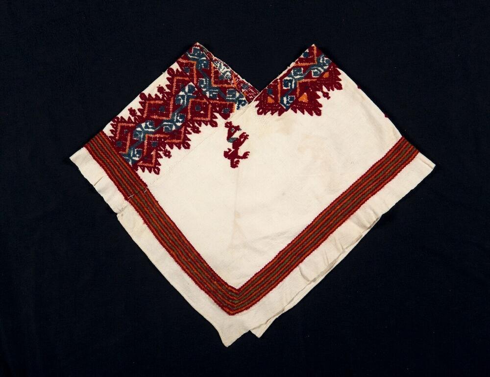 Witte quechquémitl met motieven in het rood