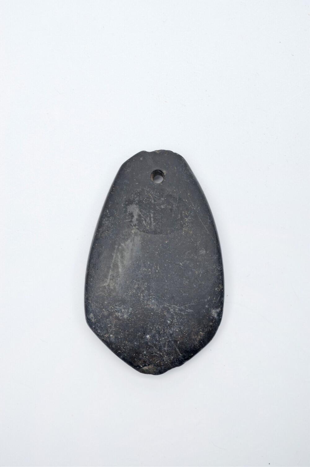Stenen hanger, gebruikt als amulet