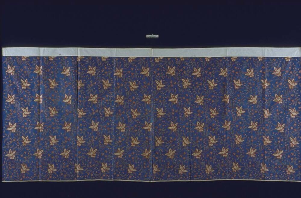 Wikkelrok met rood-witte bloemen op blauwe basis