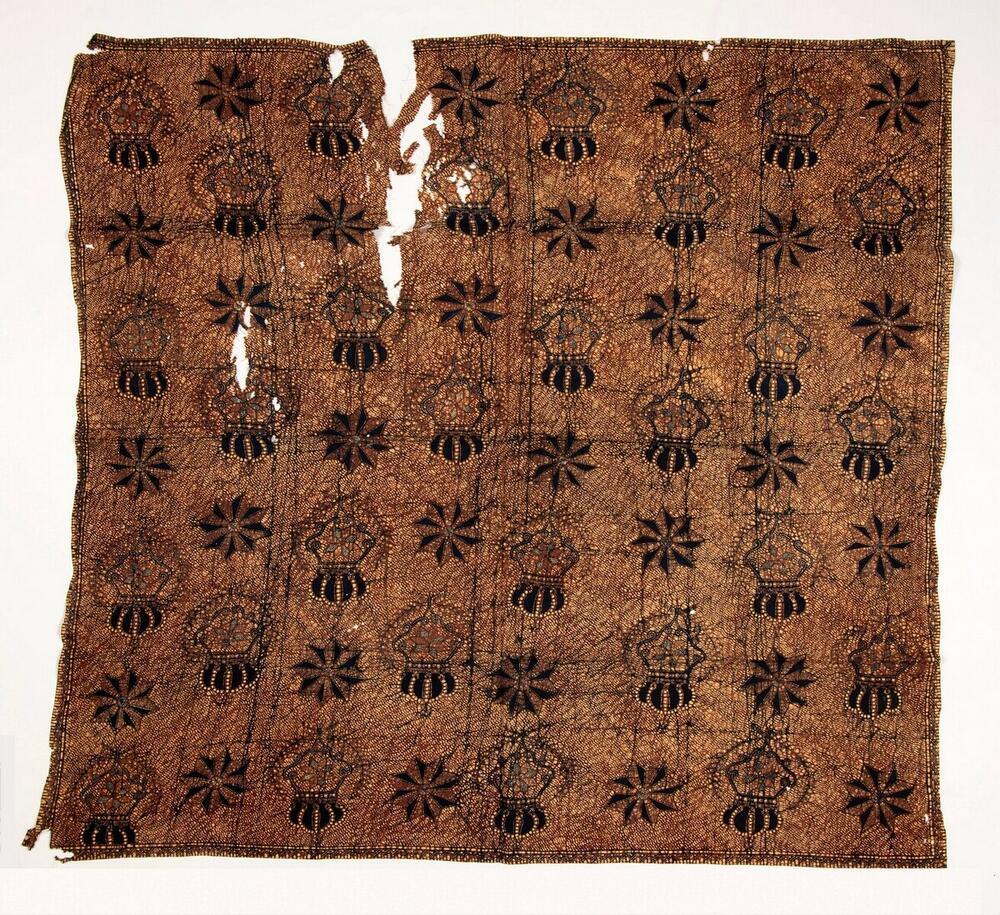 Hoofddoek van katoen, versierd met batik met westerse motieven, sterren en kronen en lauwerkransen