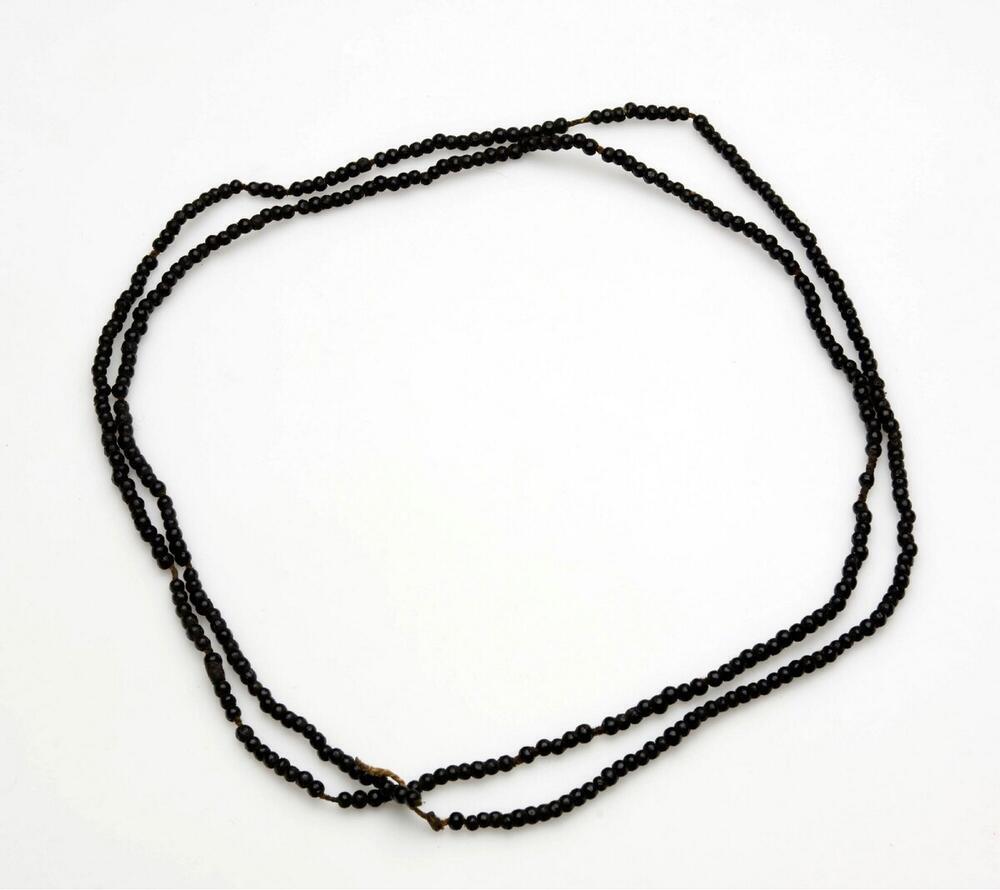 Kralenketting met geregen vruchtenpitten en vier dierenstaarten