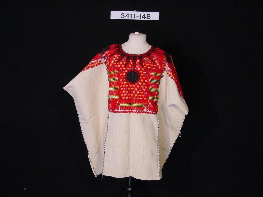 Lange witte vrouwenblouse met borduursel onder de halsopening