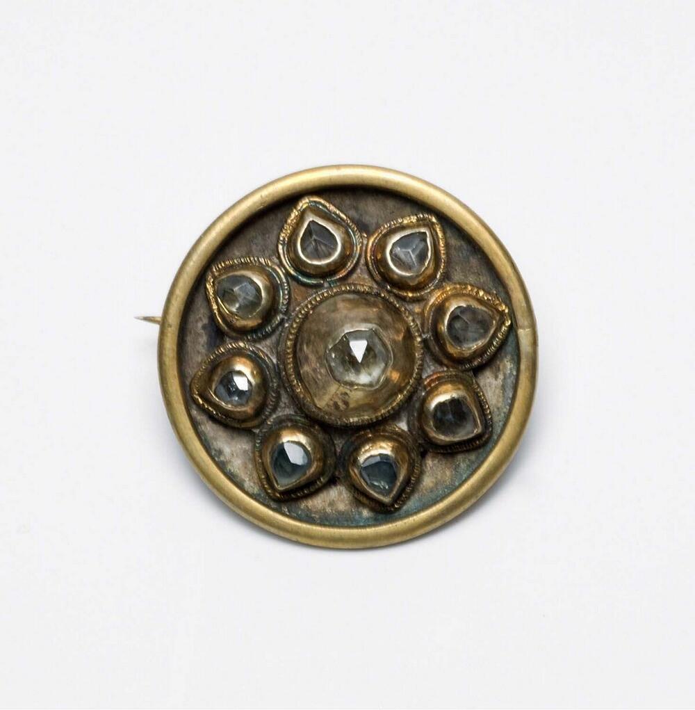 Broche van zilver en koper met sierstenen, vervaardigd uit een oorsieraad