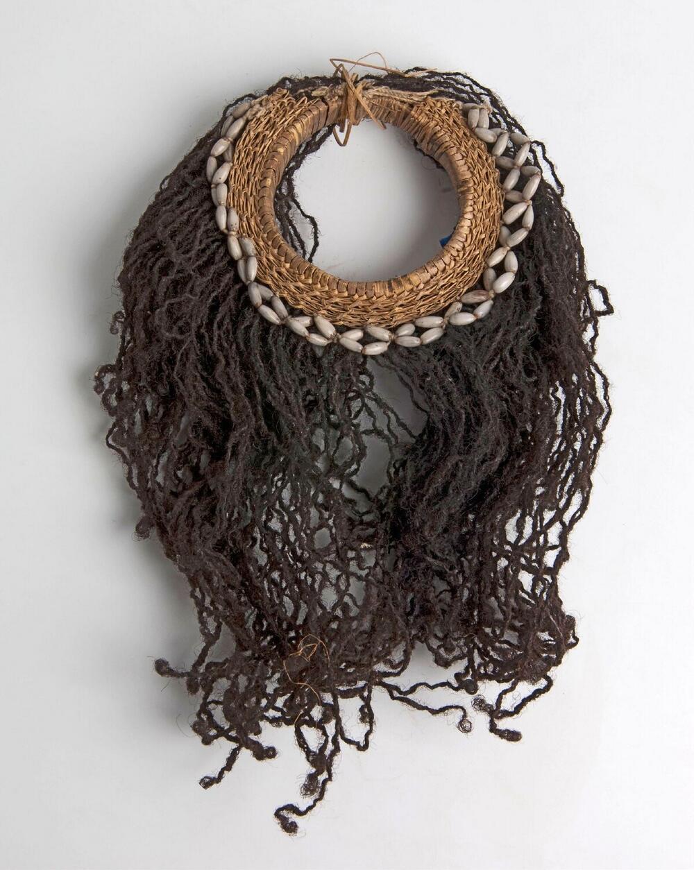 Armband van gevlochten rotan met jobstranen en afhangend mensenhaar