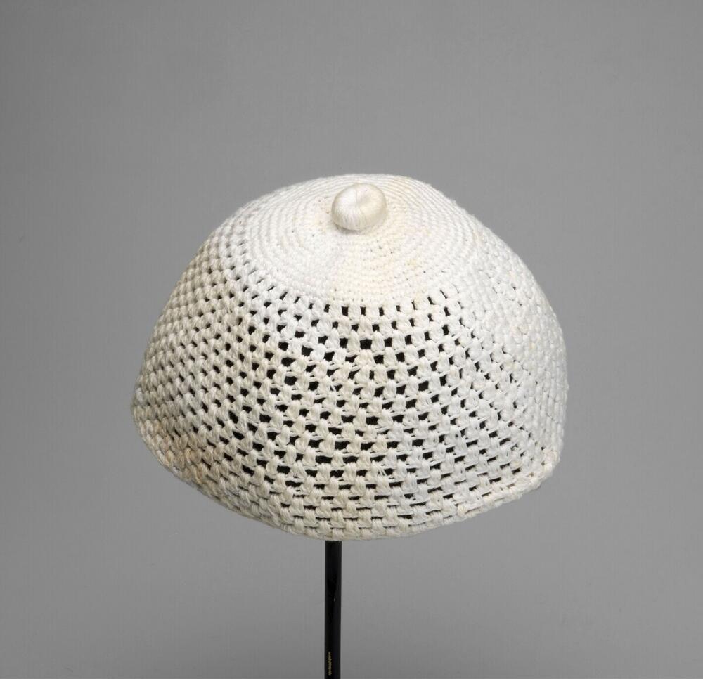 Witte gehaakte muts met platte, ronde knoop