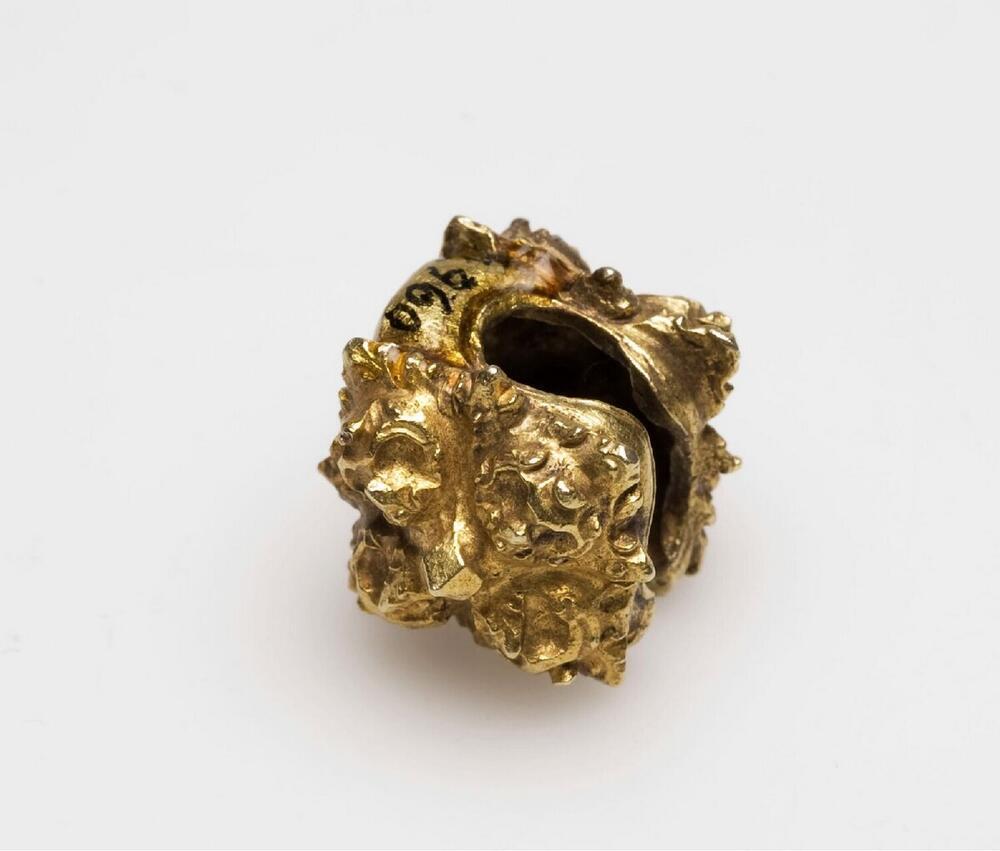 Gouden oorring, aan de voor en achterkant voorzien van een vierbladig rozet