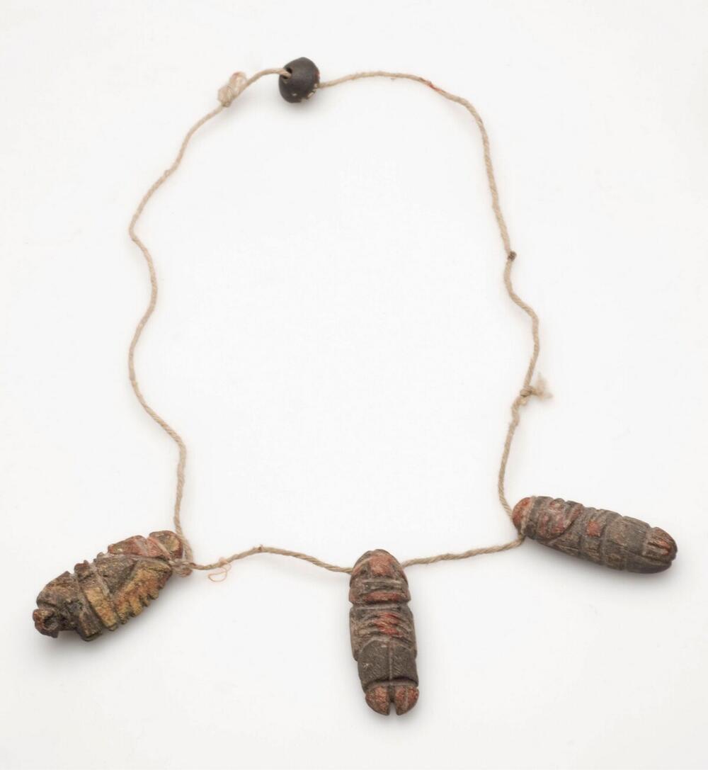 Halssieraad met drie stenen hangers met mensfiguren en een kraal